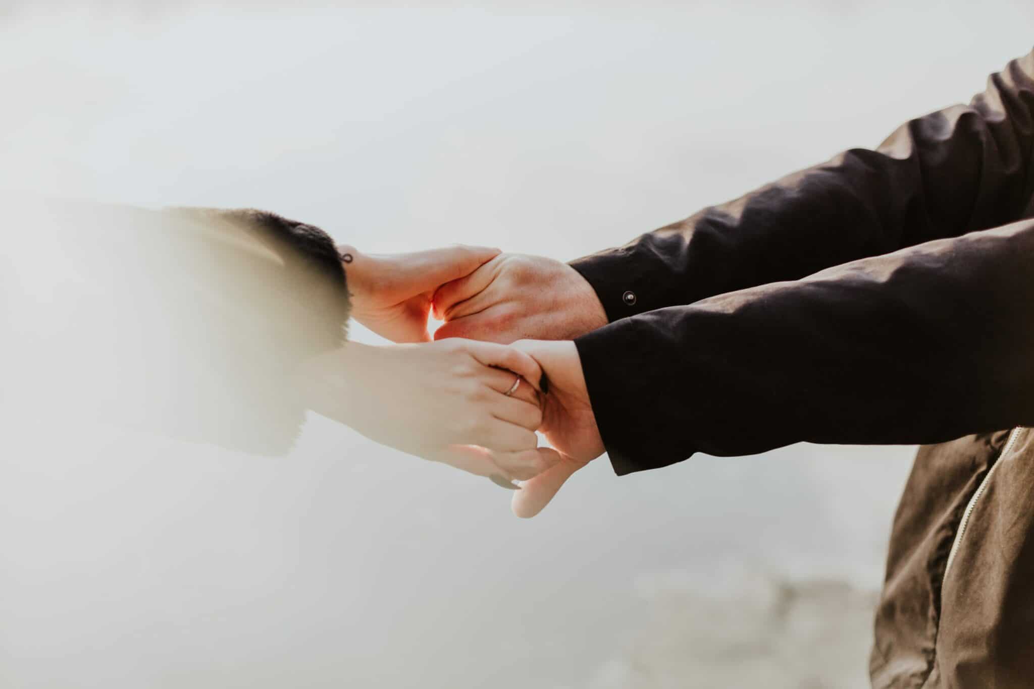 an image of two people holding hands after learning how to support someone in recovery