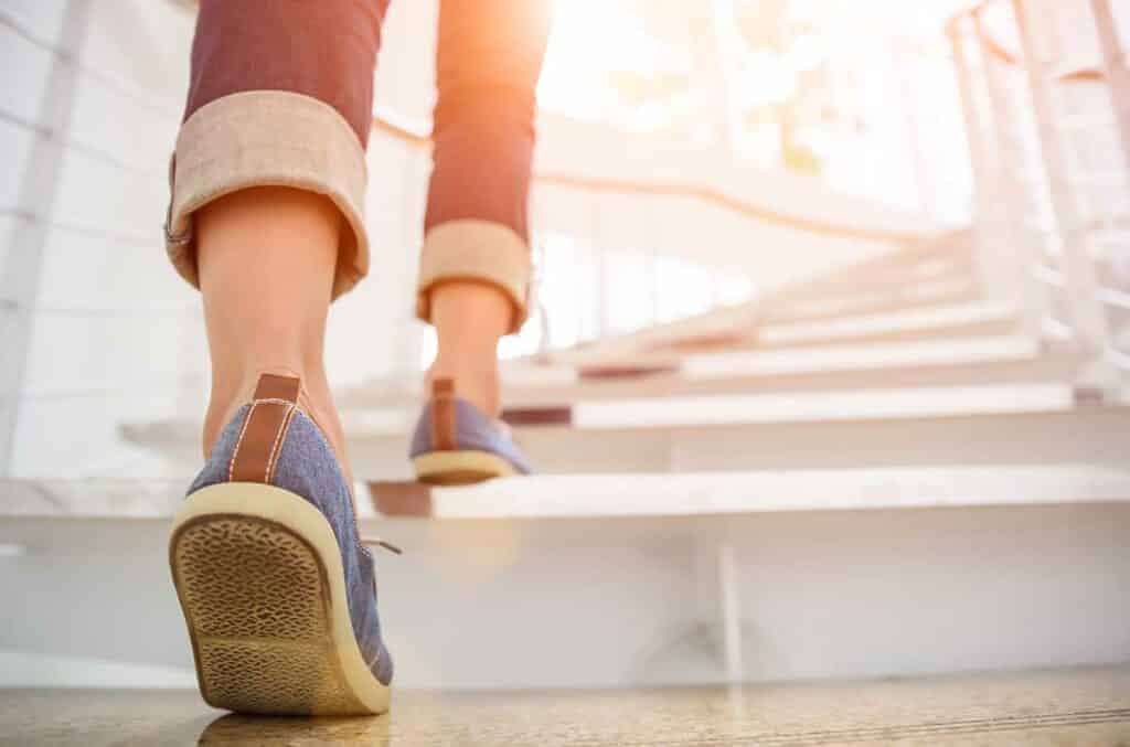 an image of a women climbing stairs representing the levels of addiction treatment