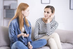 Two women discussing how much it costs to go to rehab