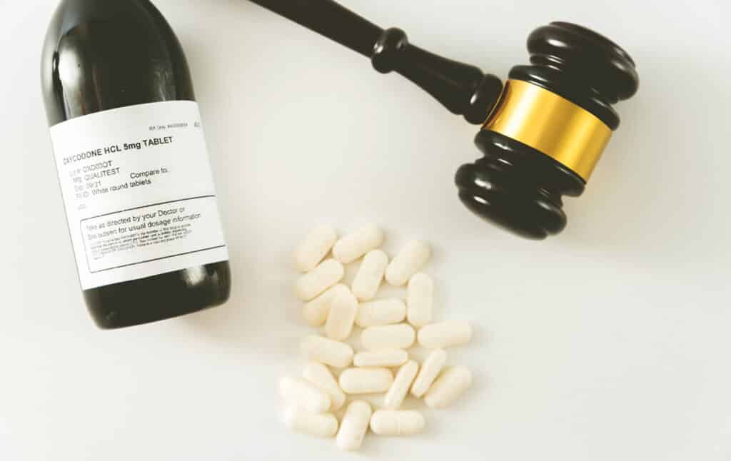 an image of a gavel and oxycodone, symbolism for the opioid epidemic