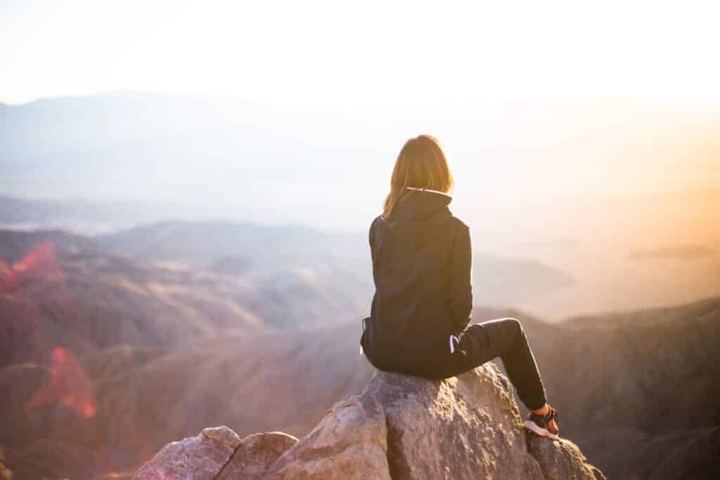 An image of a woman on a mountain overcoming mental health issues