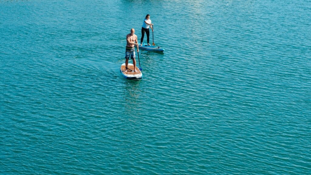 An image of two people paddle boarding at a Laguna Beach Rehab