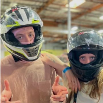 2 people posing in motorcycle helmets at K1 speed