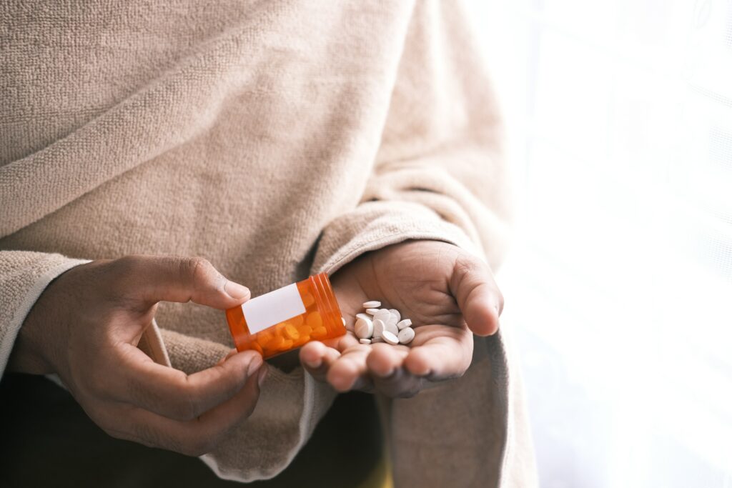 Woman shaking a container of a commonly prescribed antidepressant medications into her hand. 