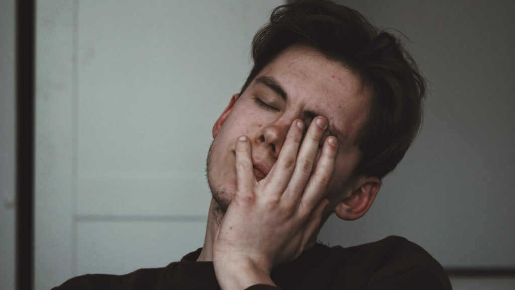 an image of a man with his hand on his face to represent opioid overdose treatment. 