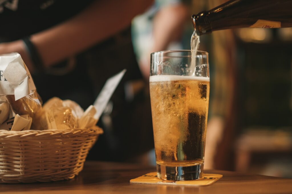 an image of a beer being poured representing the social acceptance of alcohol and alcohol addiction
