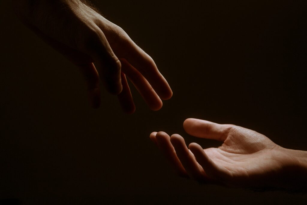 two hands reach to each other to representto represent heroin detox and withdrawal.