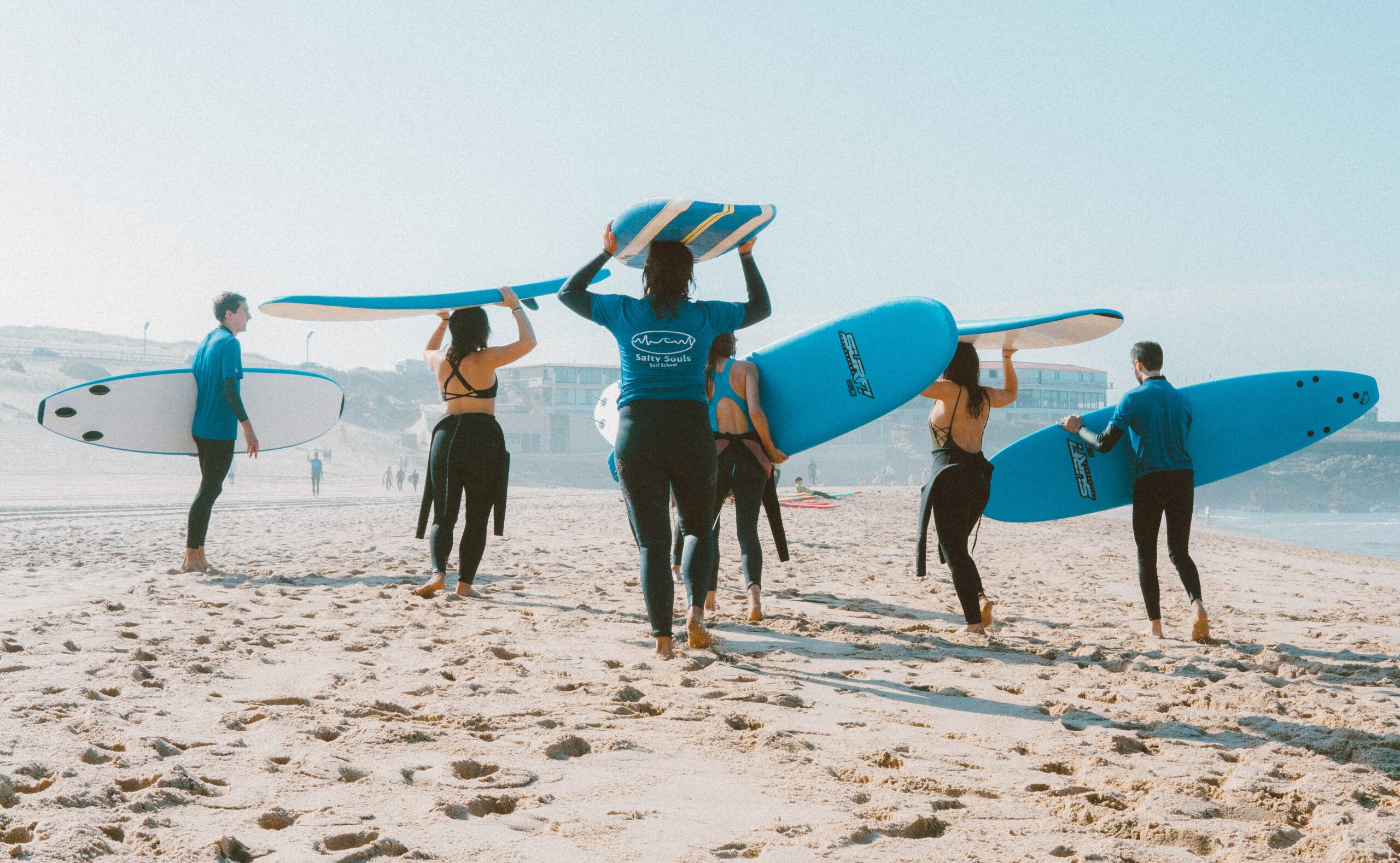 People are getting ready to go surfing at a newport california beach to represent 5 Best Non-Drinking Activities in Newport Beach and sober activities in newport beach.