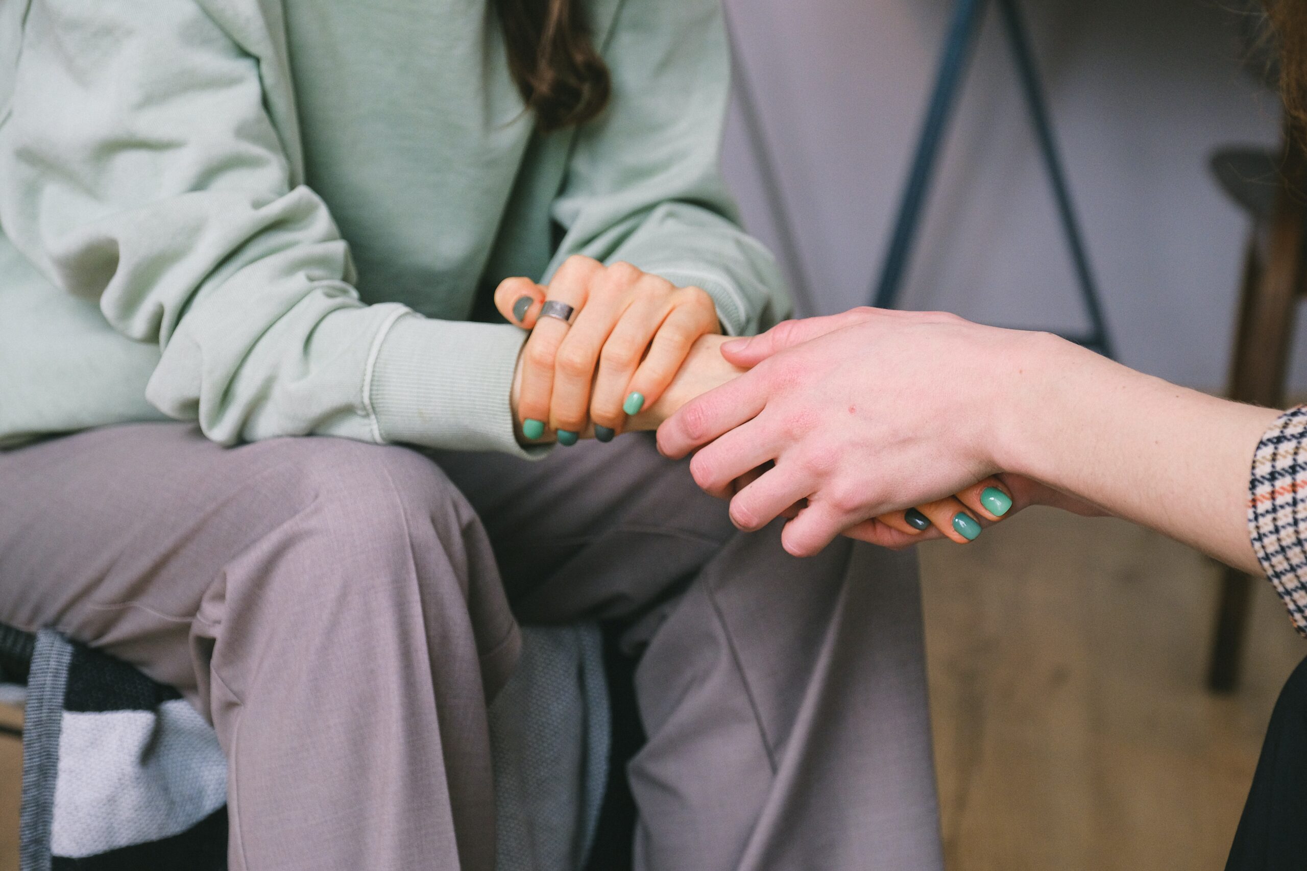 two people hold hands to represent heroin detox and withdrawal.