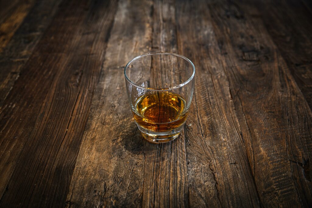 an image of a glass of liquor on a wooden table