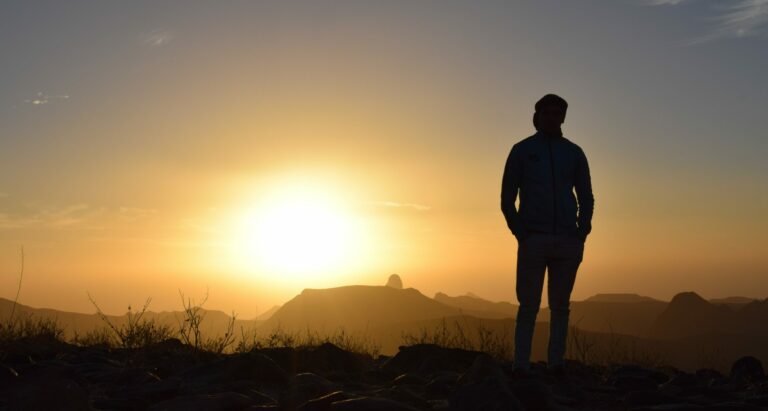 A man stands on a hill at sunset to represent the question "is Xanax a barbiturate?".