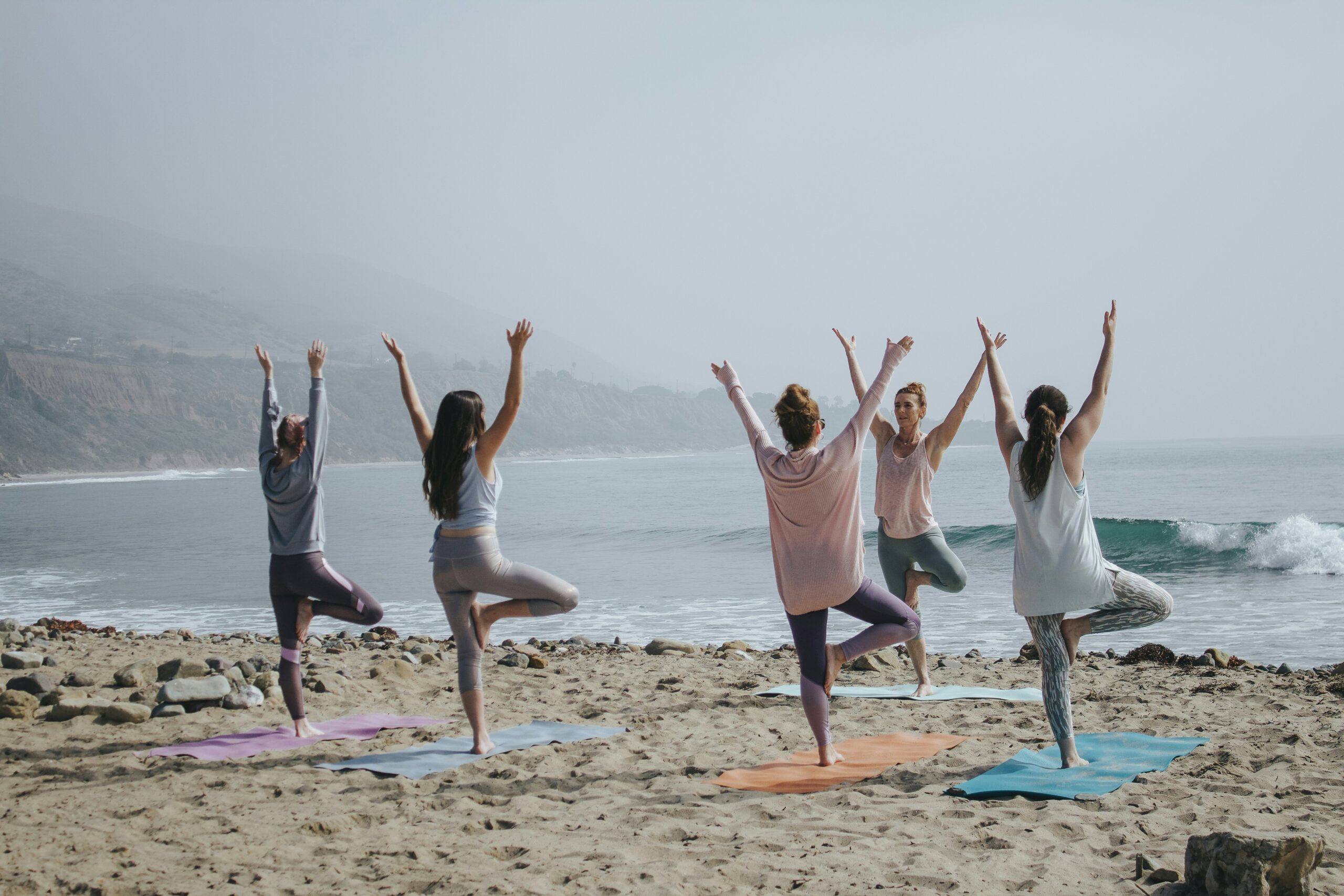 group doing yoga on the beach