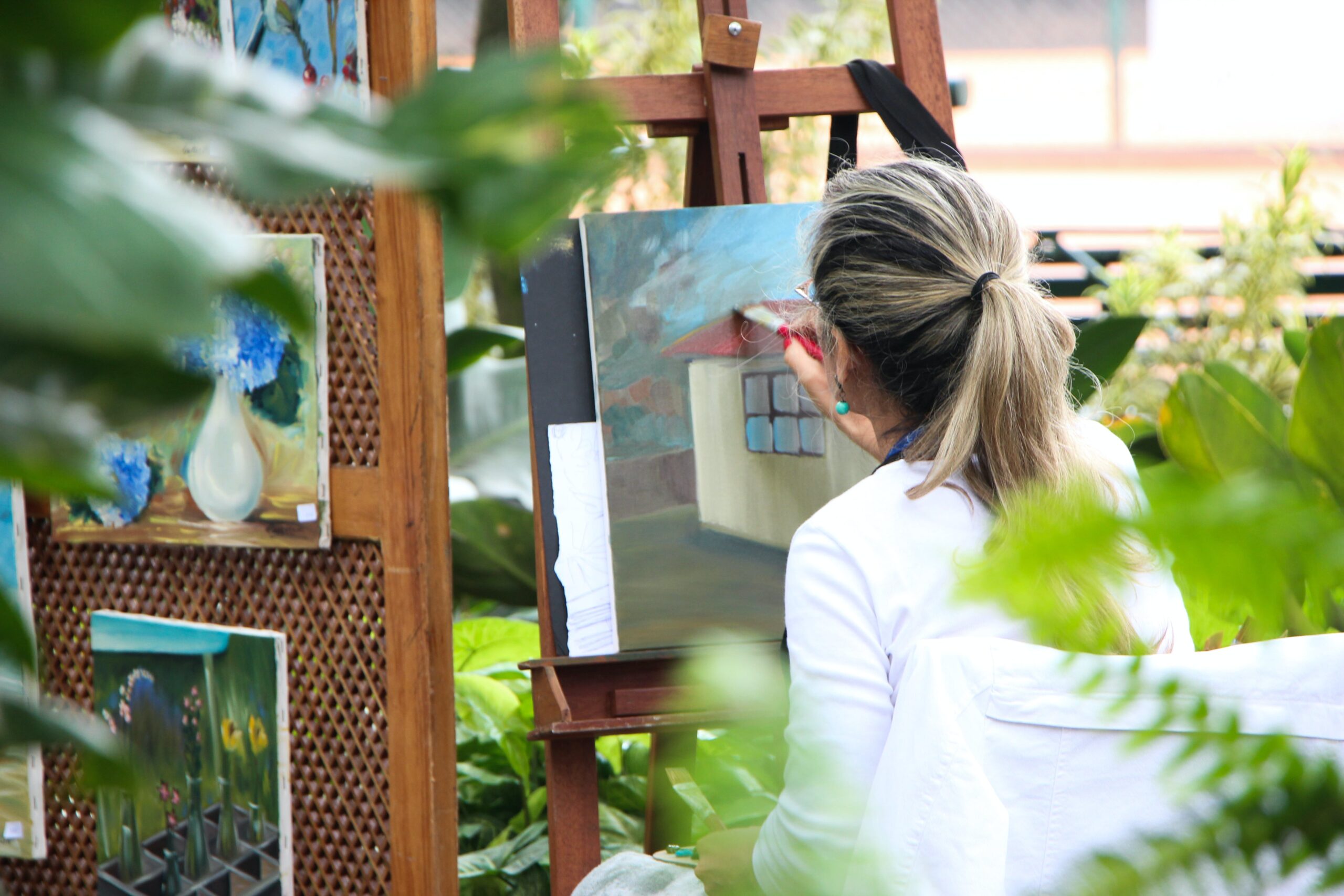 An image of a woman painting a canvas, using creative expression as therapy