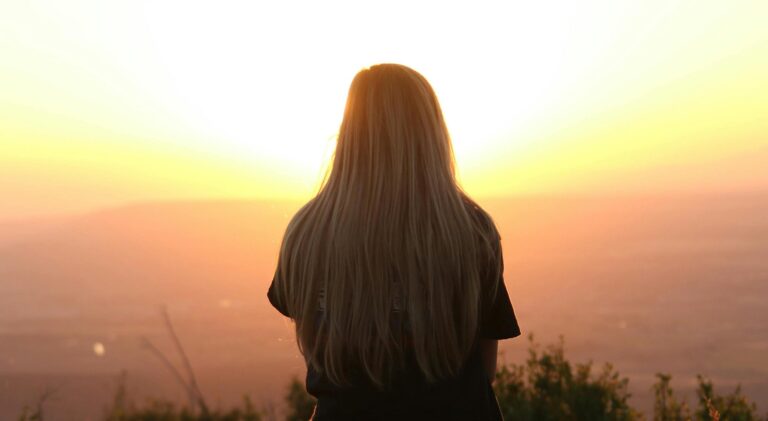 Woman looking at sunset representing what is trauma therapy