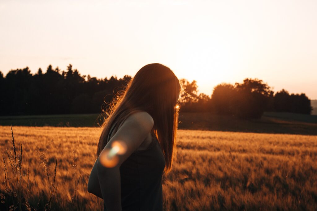 a woman looking out on a field at sunset representing stadol side effects